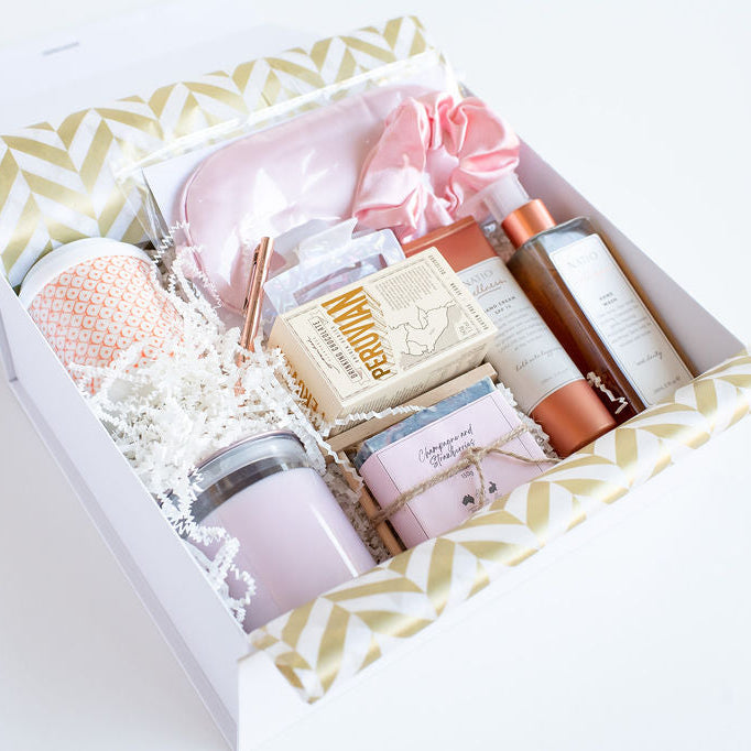 Luxury Gift box with various items including skincare products and a candle on a white background